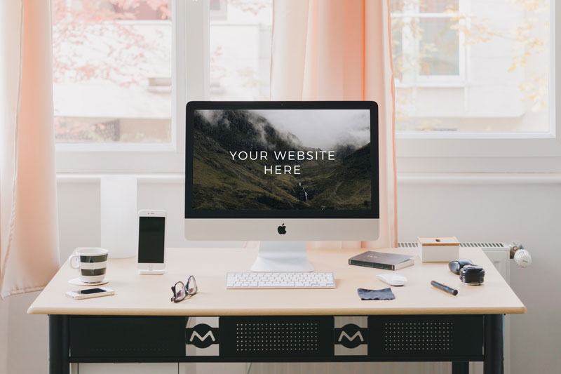 Mockup of an iMac on a Desk in a Room