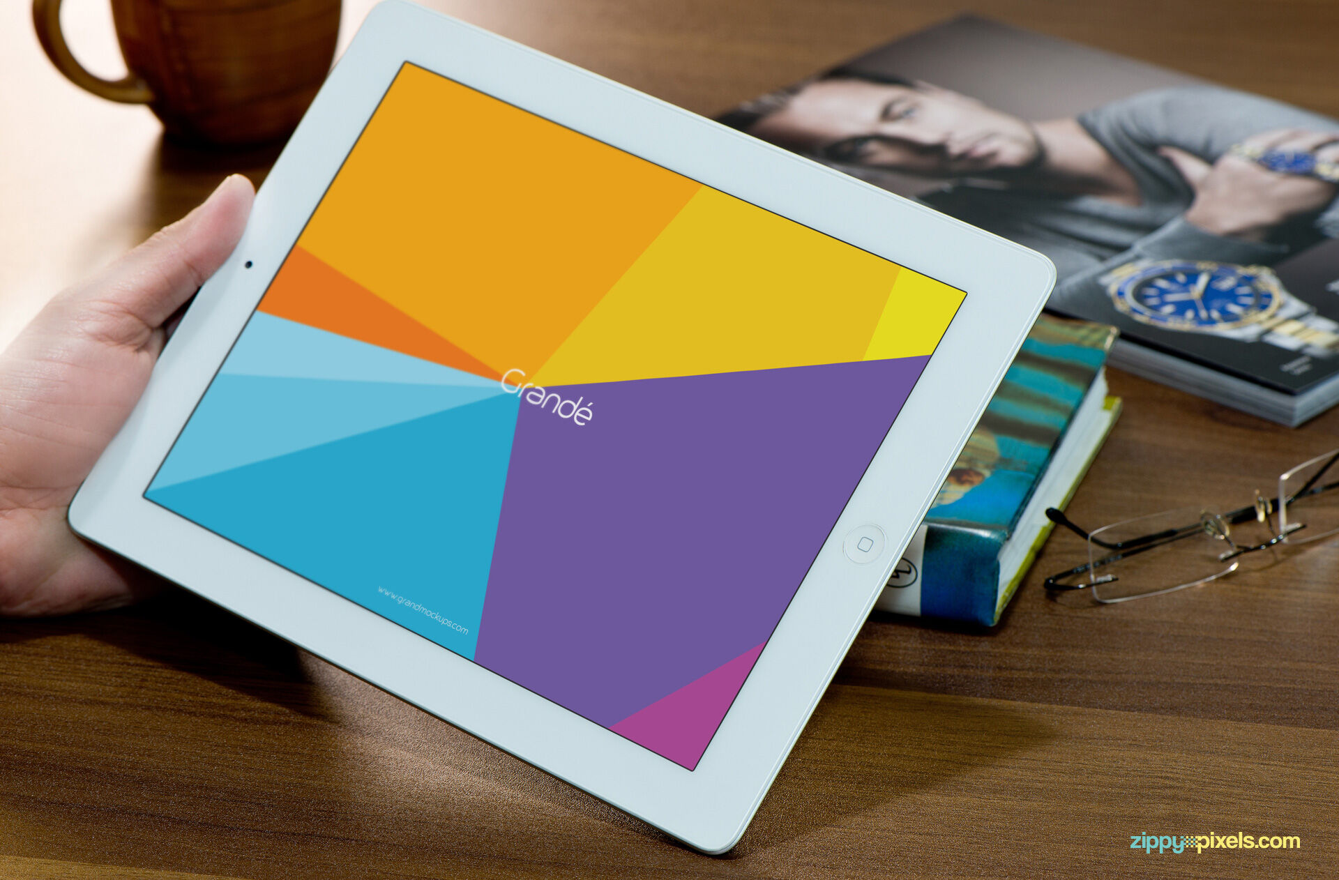 Mockup Featuring Hand Holding iPad on Wooden Table