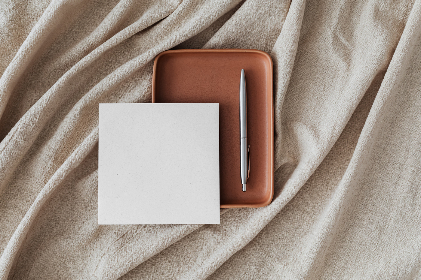 Top View of Square Card Mockup with Pen on Fabric preview