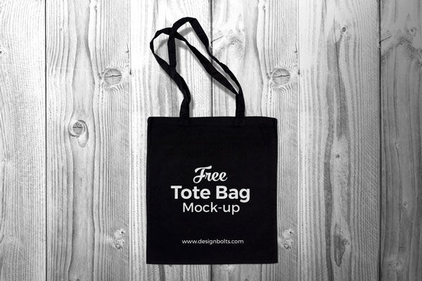 Top View Black Cotton Tote Shopping Bag on Wooden Floor Mockup preview