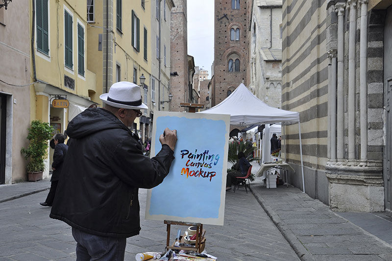 Mockup of a Man Painting on a Canvas in Street