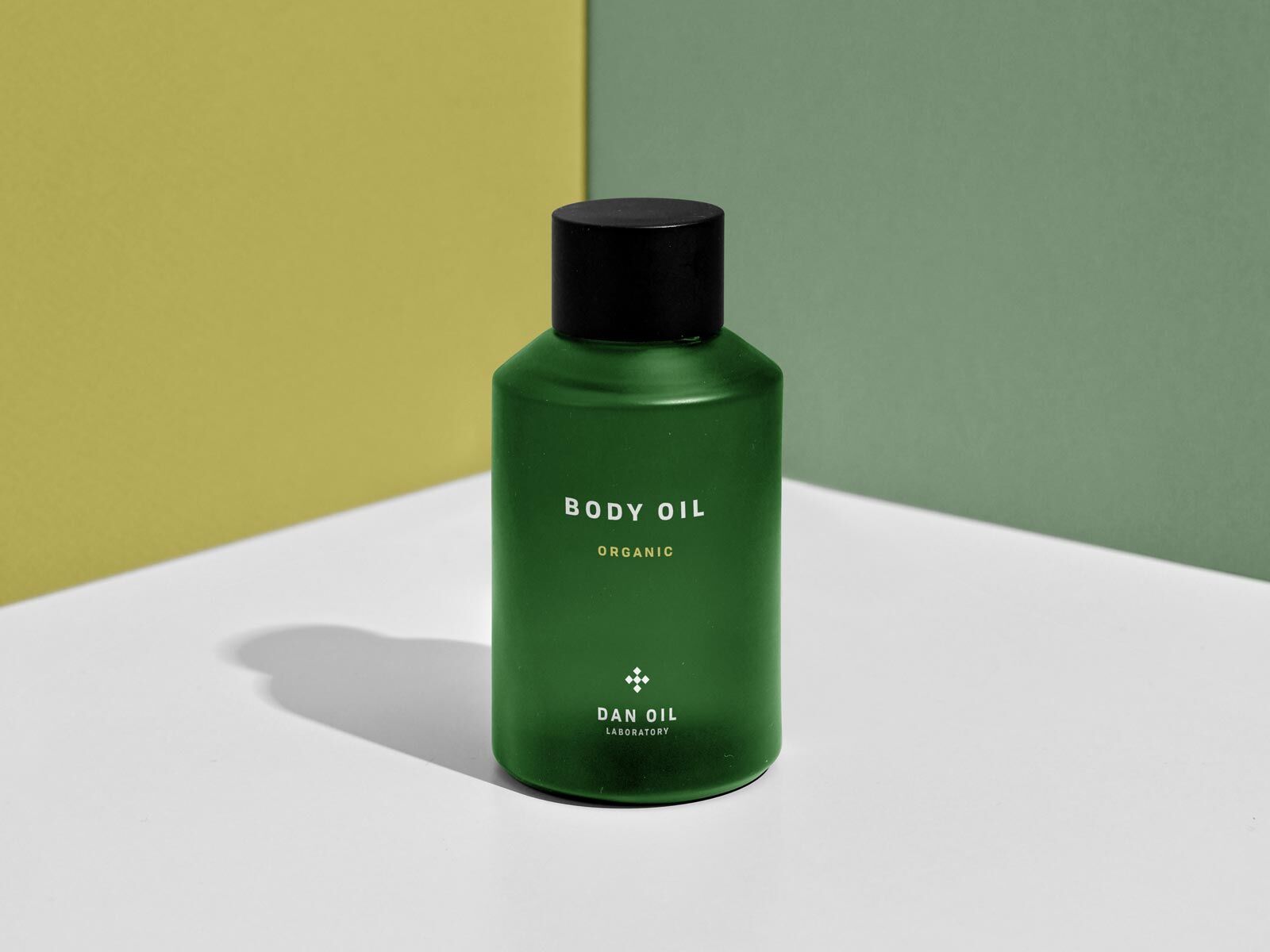 Front View of Body Oil Bottle at the Corner of Two Walls Mockup preview